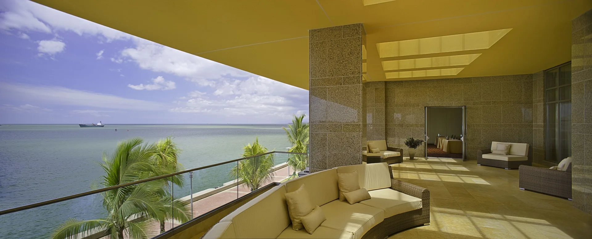 Covered waterfront terrace with lounge seating and sea views at Hyatt Regency Trinidad.
