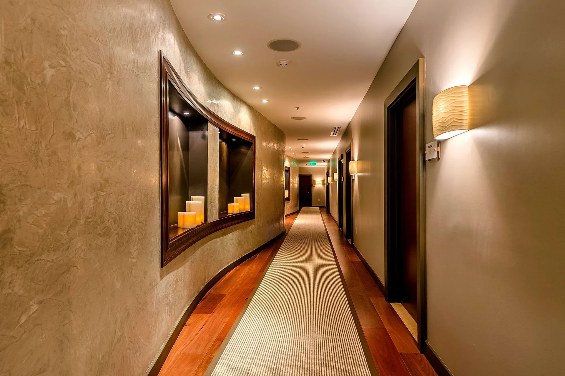 Warmly lit guest corridor with wall sconces and candle display at Hyatt Regency Trinidad.
