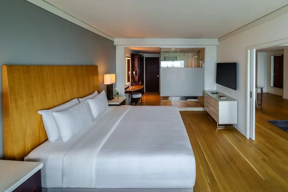 King bed guest room with glass-walled bath at Hyatt Regency Trinidad.