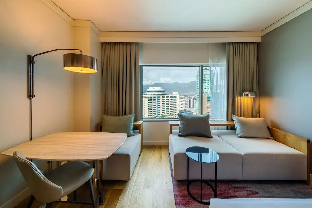 Window seating, dining table and city view in a guest room at Hyatt Regency Trinidad.