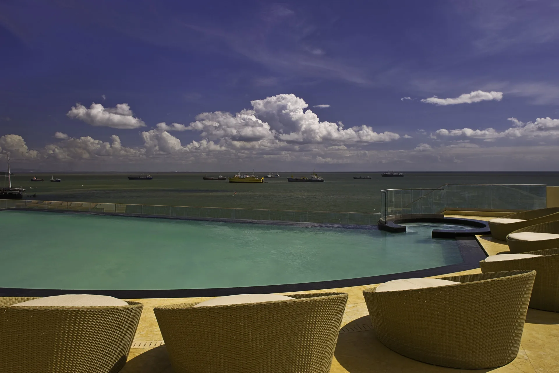 Infinity pool and curved lounge chairs facing the sea at Hyatt Regency Trinidad.