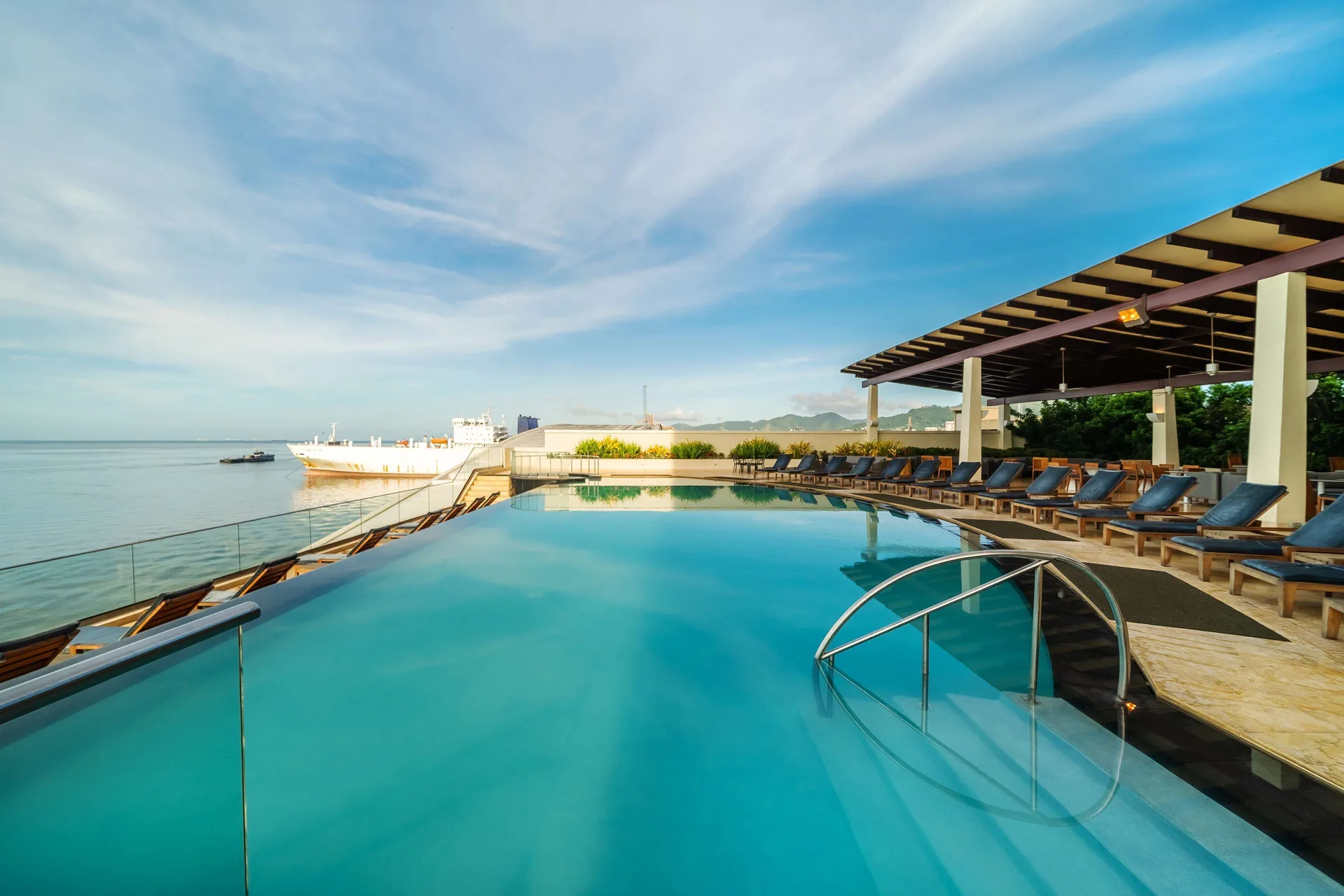 Rooftop infinity pool with loungers and ocean view at Hyatt Regency Trinidad.