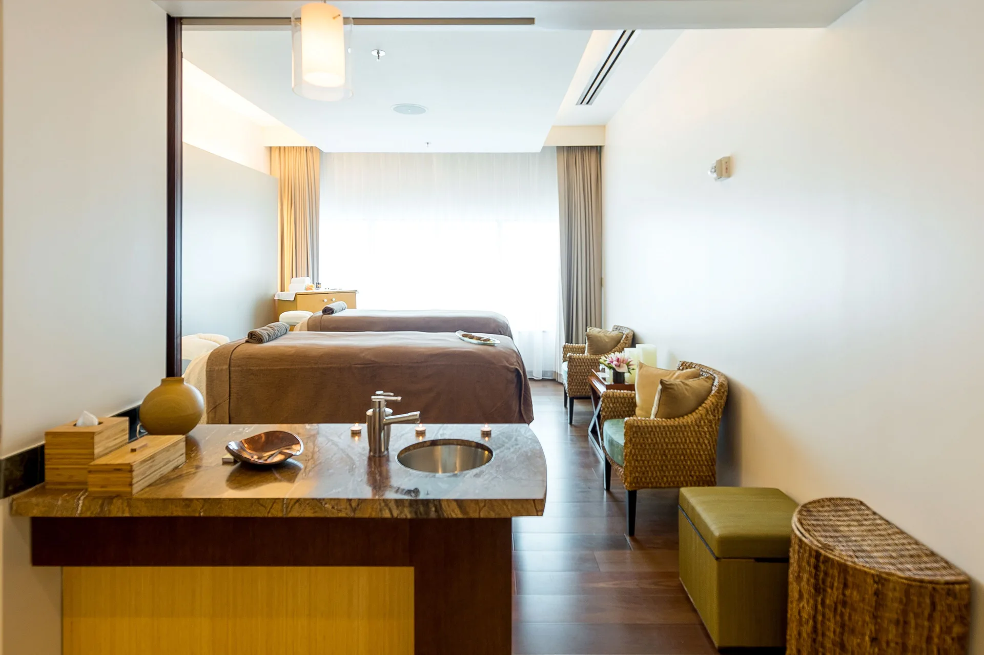 Spa treatment room with two massage tables and a sink counter at Hyatt Regency Trinidad.