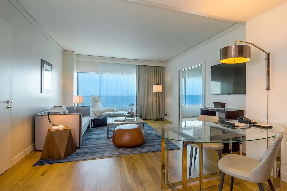 Suite living room with glass dining table and ocean view at Hyatt Regency Trinidad.