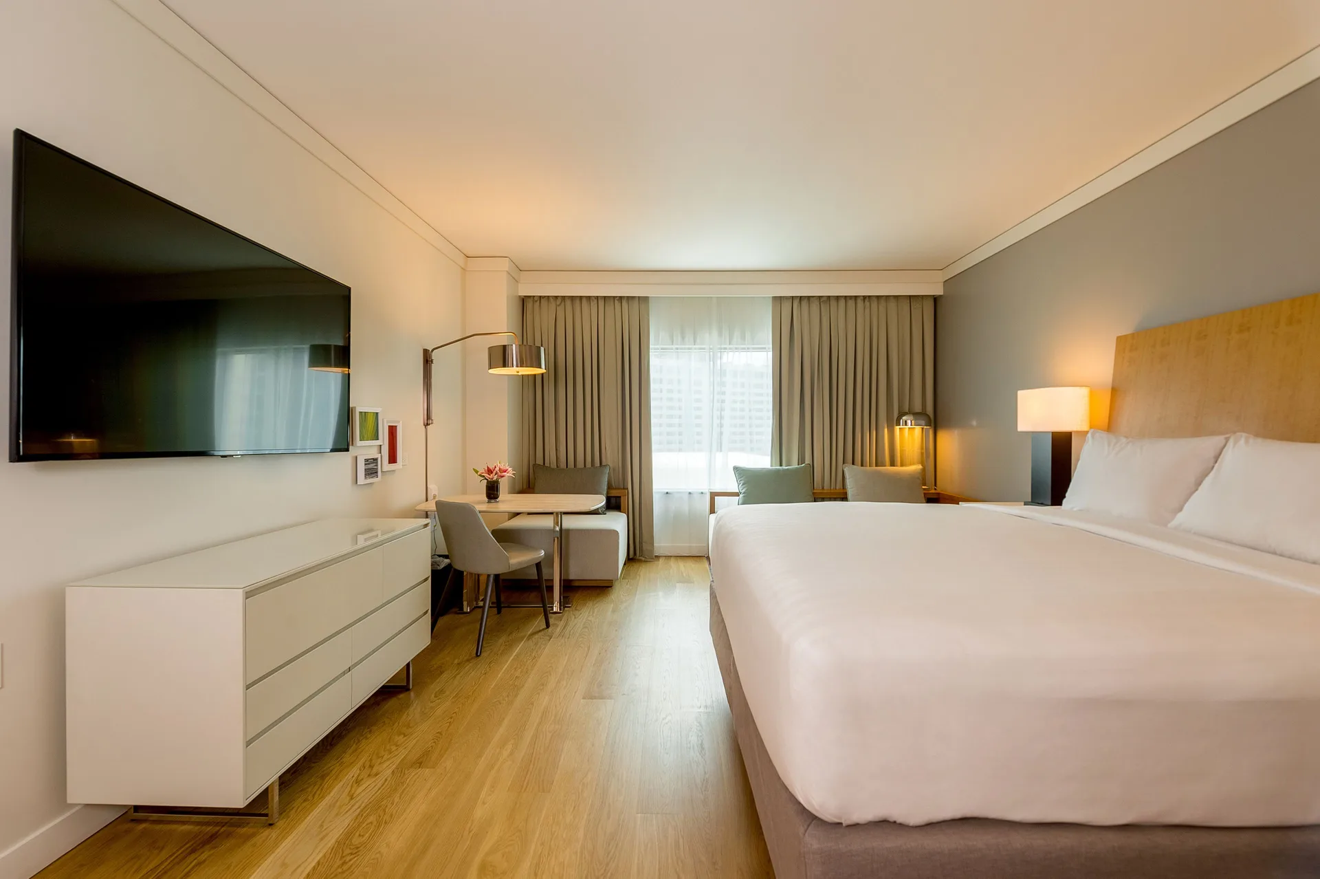 King bed guest room with TV, desk, and curtained window at Hyatt Regency Trinidad.