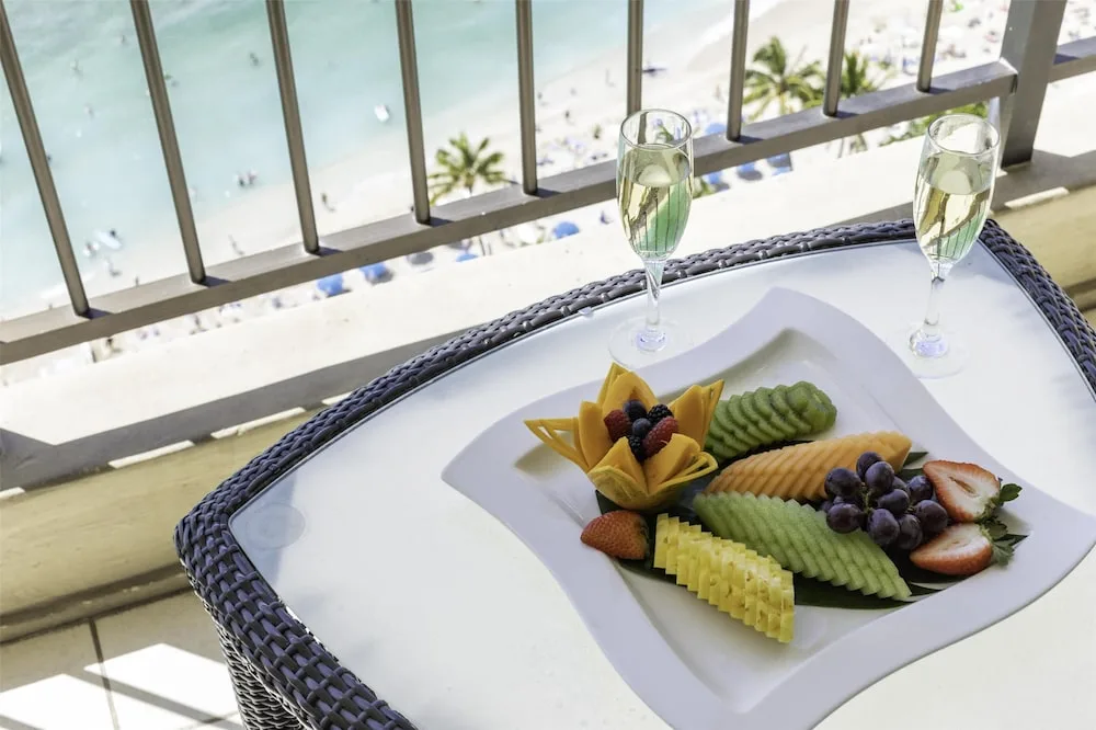 Fruit plate and sparkling drinks on a balcony at Hyatt Regency Waikiki Beach Resort & Spa.