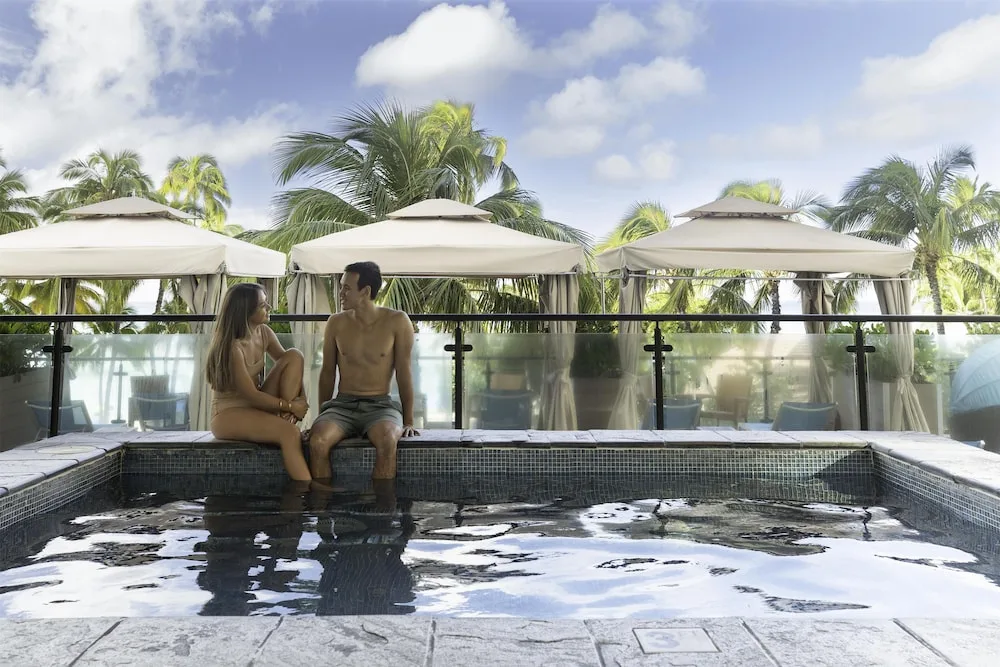 Couple sitting by the pool cabanas at Hyatt Regency Waikiki Beach Resort & Spa.