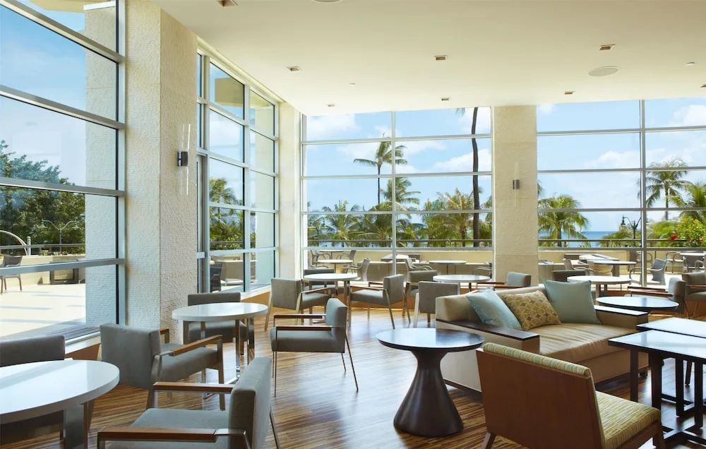 Bright lounge seating with ocean and palm views at Hyatt Regency Waikiki Beach Resort & Spa.