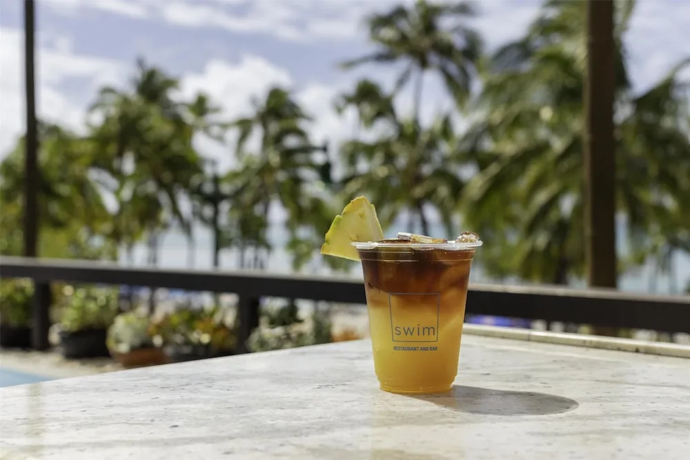 Iced drink on an outdoor table at SWIM at Hyatt Regency Waikiki Beach Resort & Spa.
