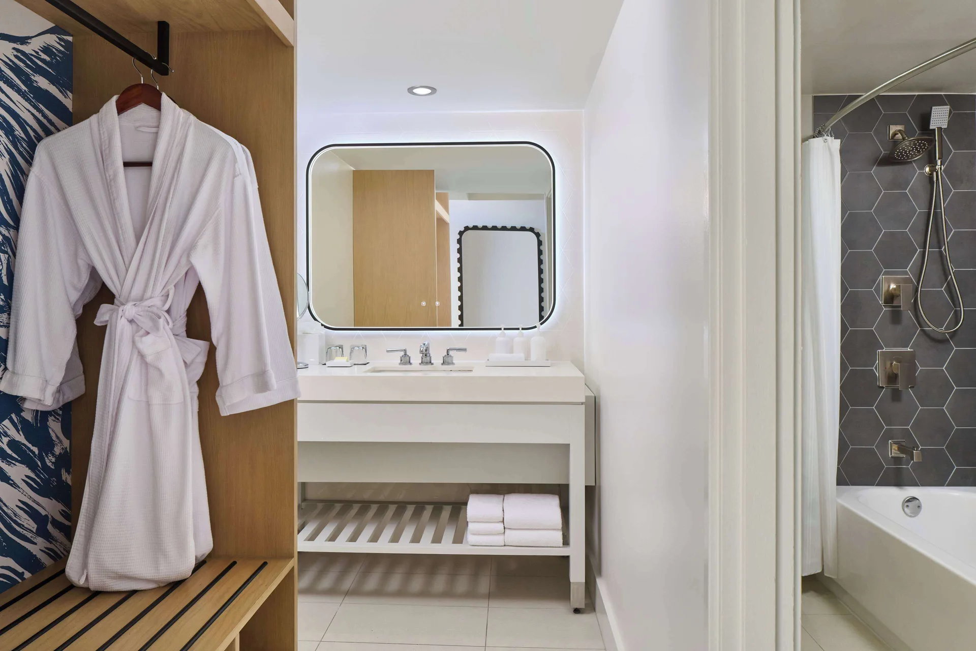 Junior Suite bathroom with robe and tub shower at Hyatt Regency Waikiki Beach Resort & Spa.
