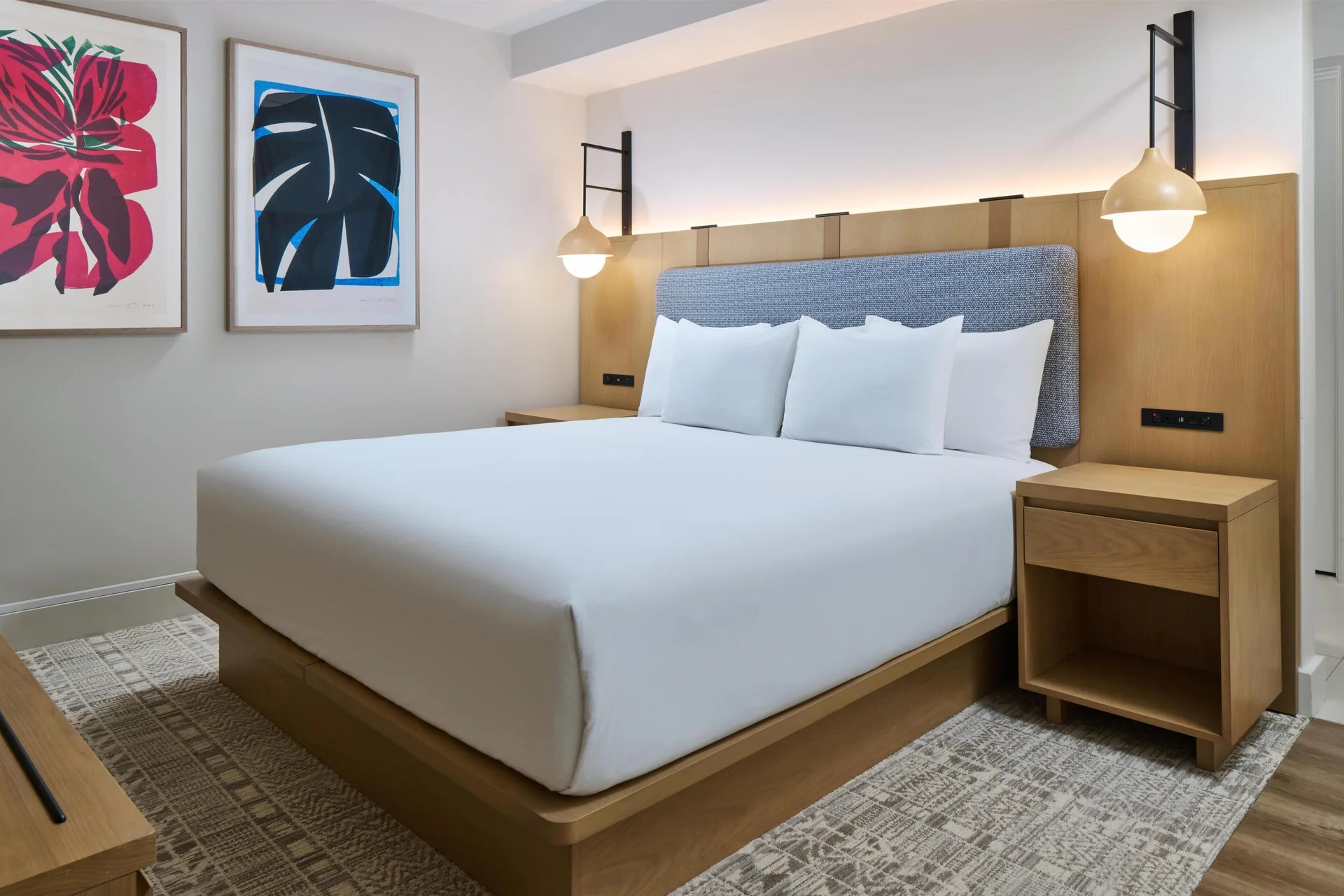 King bed in a Junior Suite at Hyatt Regency Waikiki Beach Resort & Spa with tropical wall art.