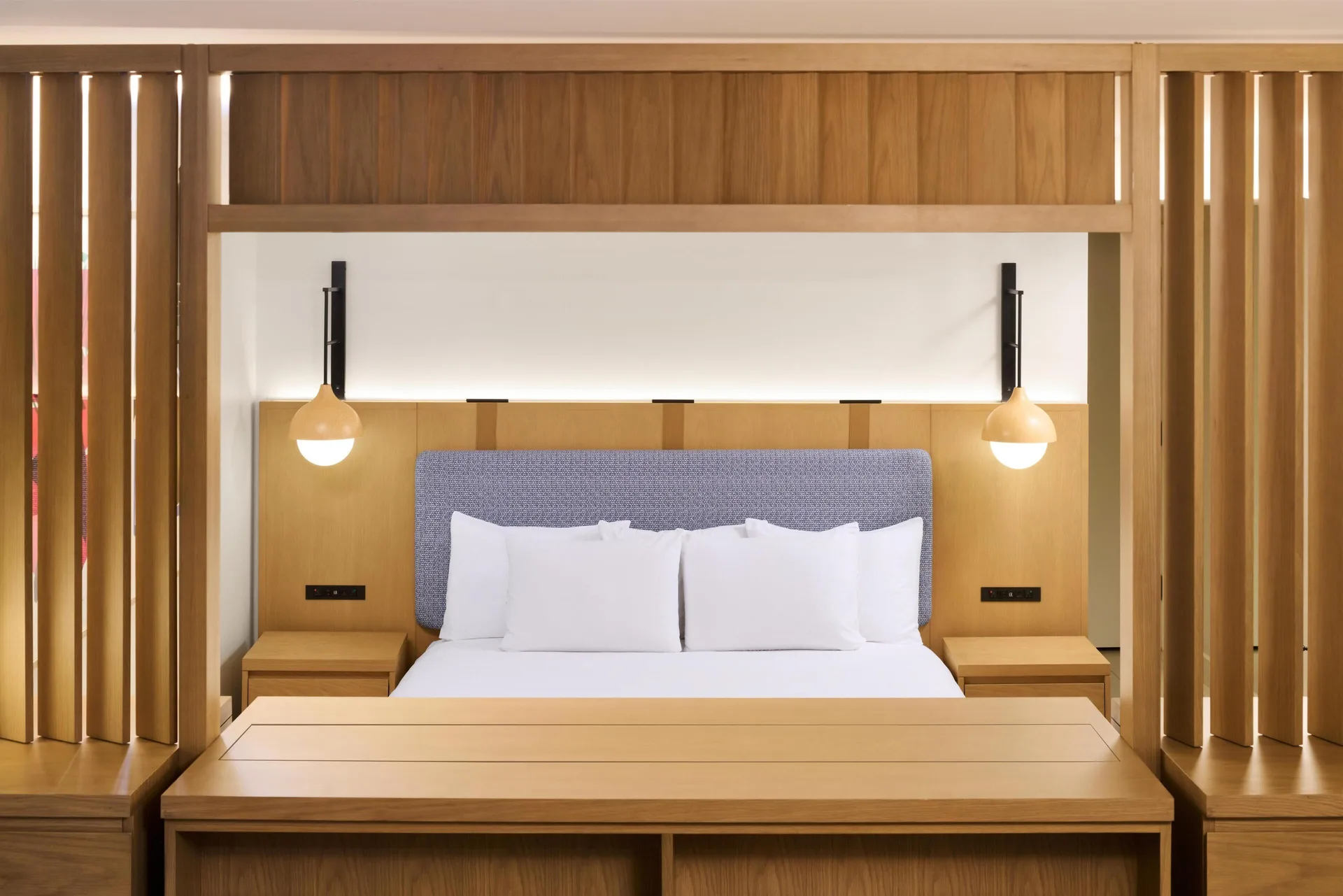 Junior Suite king bed framed by wood slats at Hyatt Regency Waikiki Beach Resort & Spa.