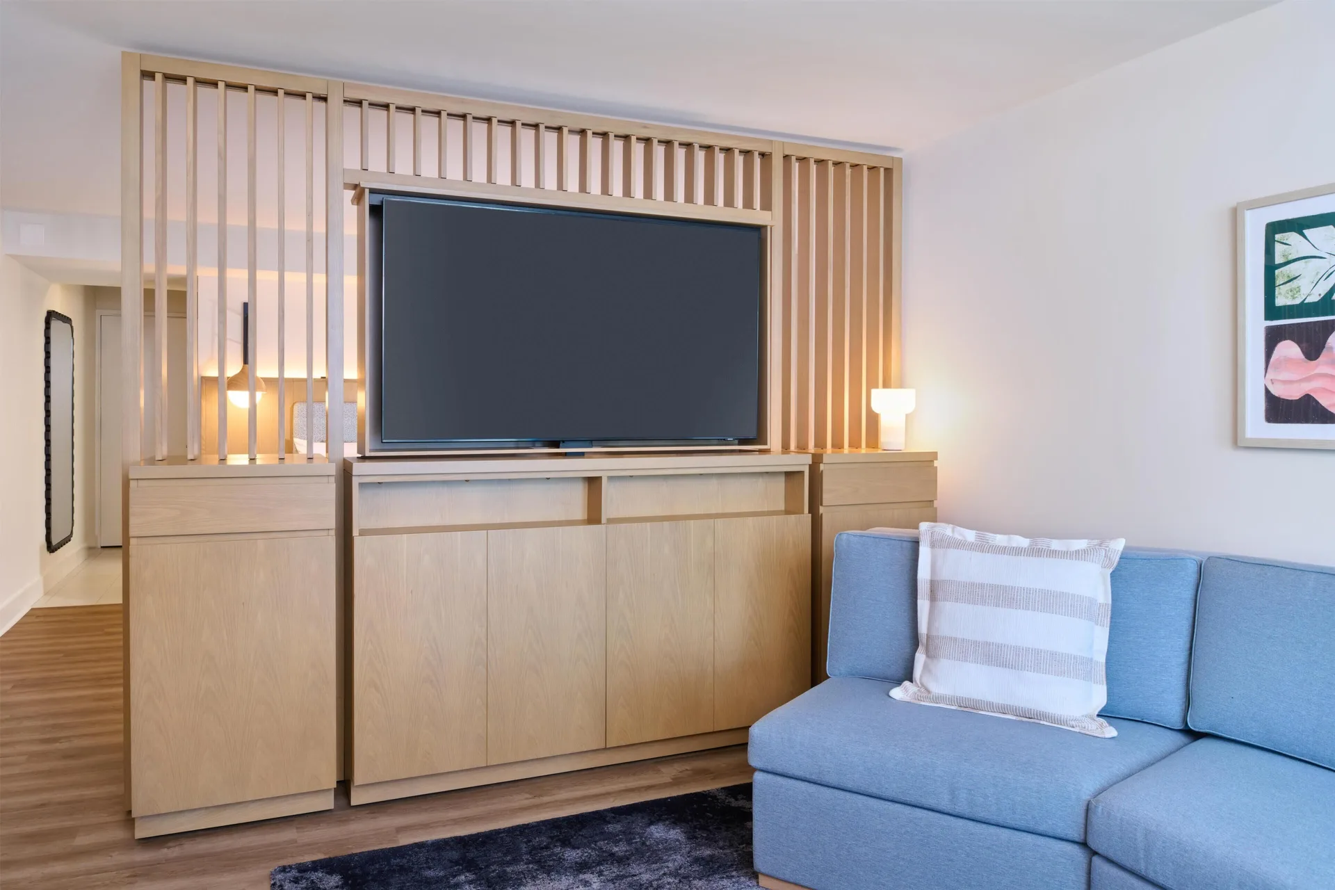 Junior suite living area with TV and blue sofa at Hyatt Regency Waikiki Beach Resort & Spa.