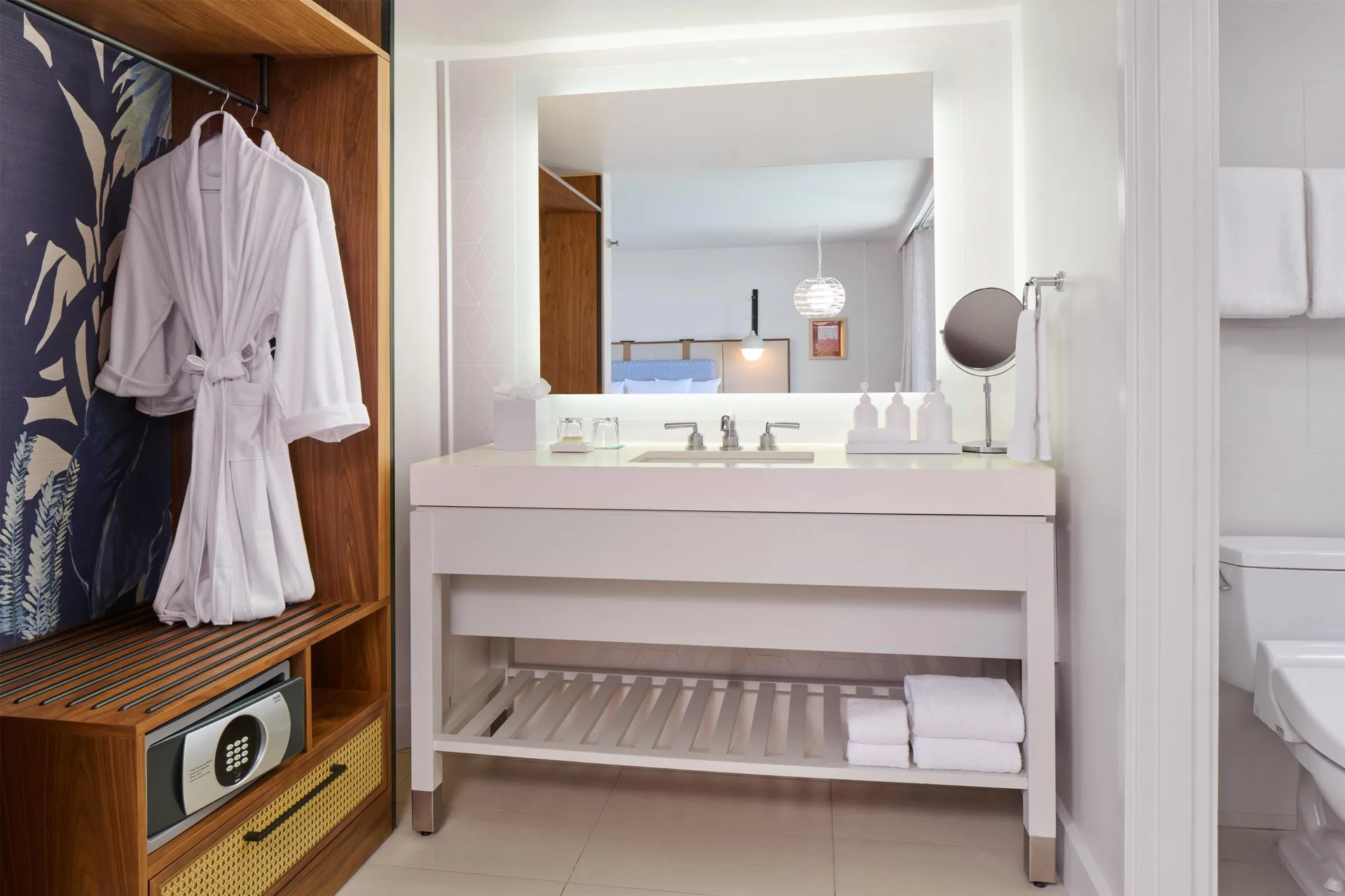 Suite vanity, robe, safe, and bathroom doorway at Hyatt Regency Waikiki Beach Resort & Spa.