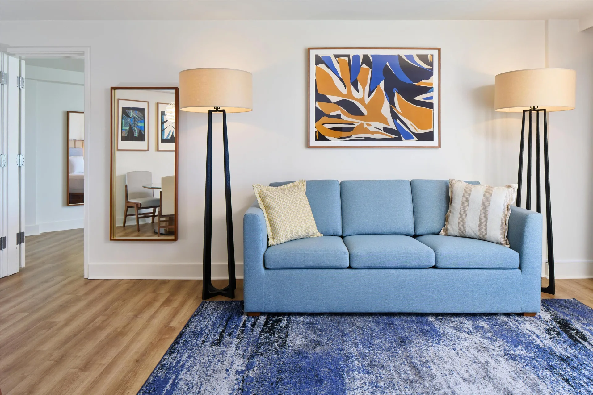 Blue sofa and floor lamps in an ocean front suite living room at Hyatt Regency Waikiki Beach Resort & Spa.