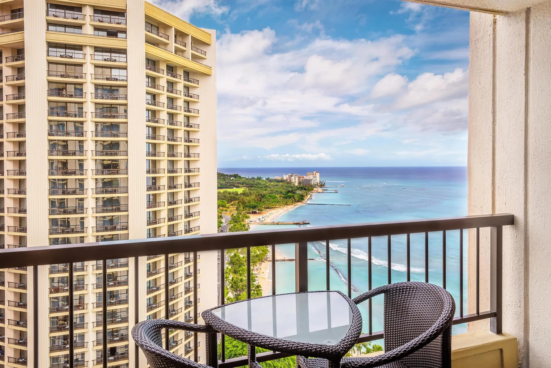 Ocean view balcony at Hyatt Regency Waikiki Beach Resort & Spa with table, chairs and shoreline.
