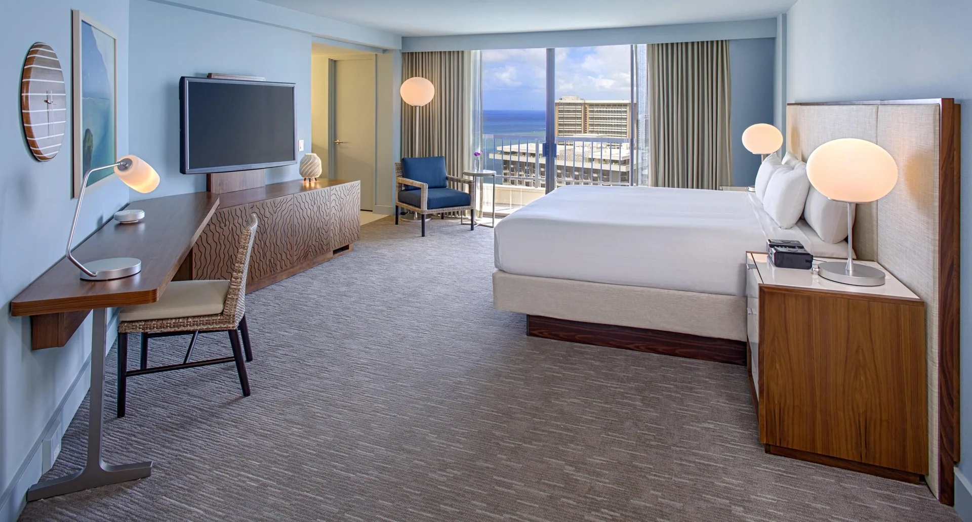 King bed Ocean View room at Hyatt Regency Waikiki Beach Resort & Spa with desk and balcony.
