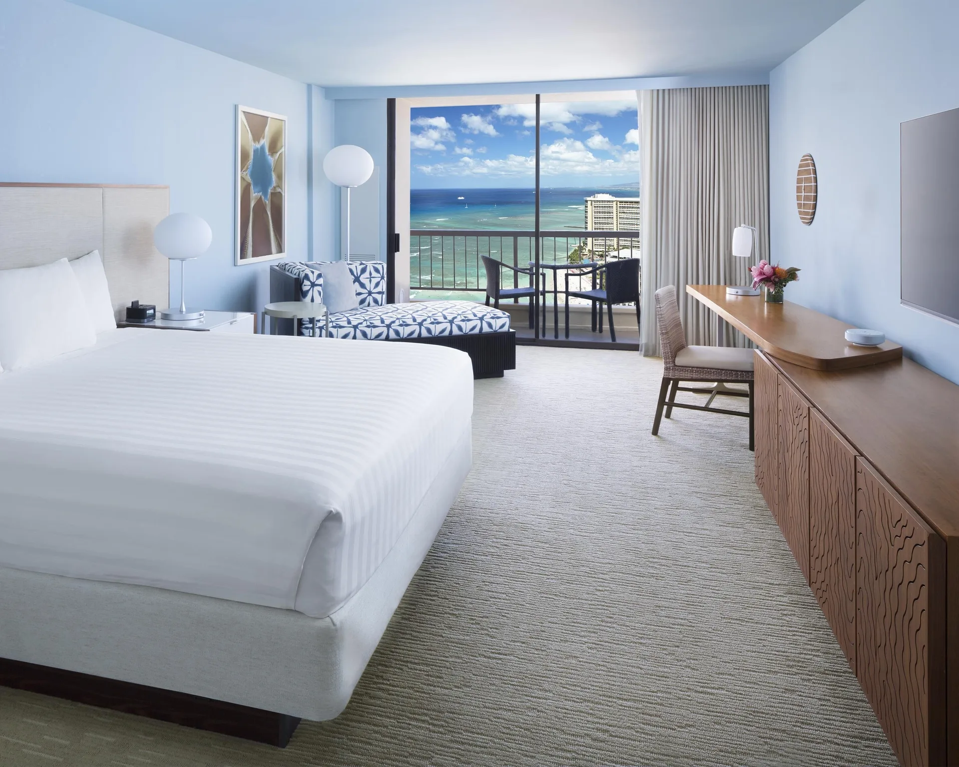King bed Ocean View room at Hyatt Regency Waikiki Beach Resort & Spa with chaise and balcony.