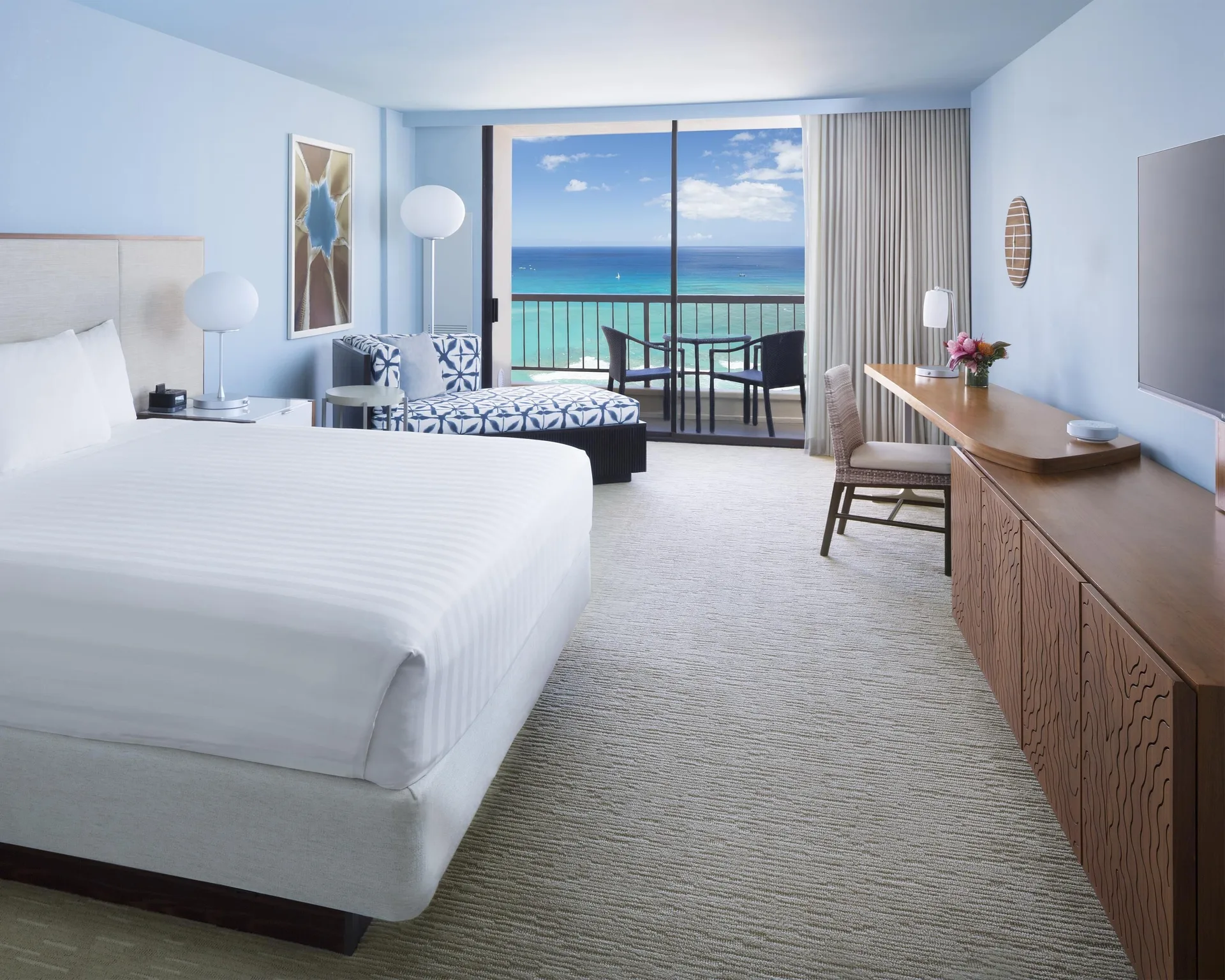 Bright king oceanfront room with desk and balcony at Hyatt Regency Waikiki Beach Resort & Spa.