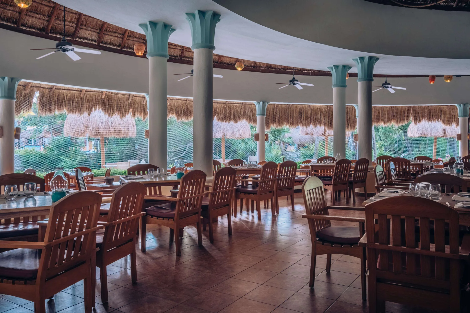 Open-air restaurant seating under a thatched roof at Iberostar Waves Paraíso del Mar.