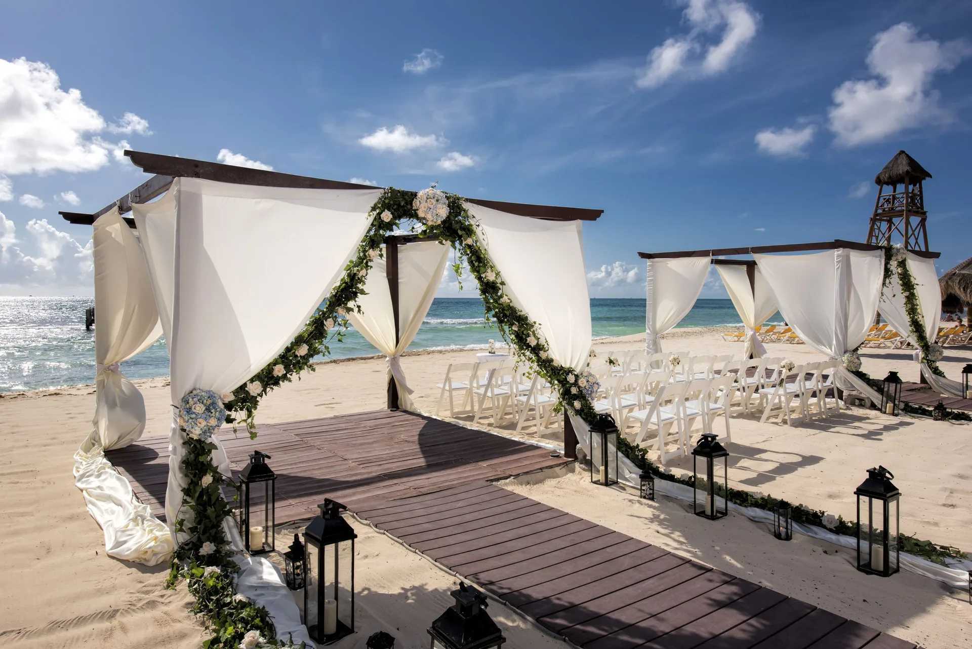 Beach wedding setup with white draped canopies at Iberostar Waves Paraíso del Mar.