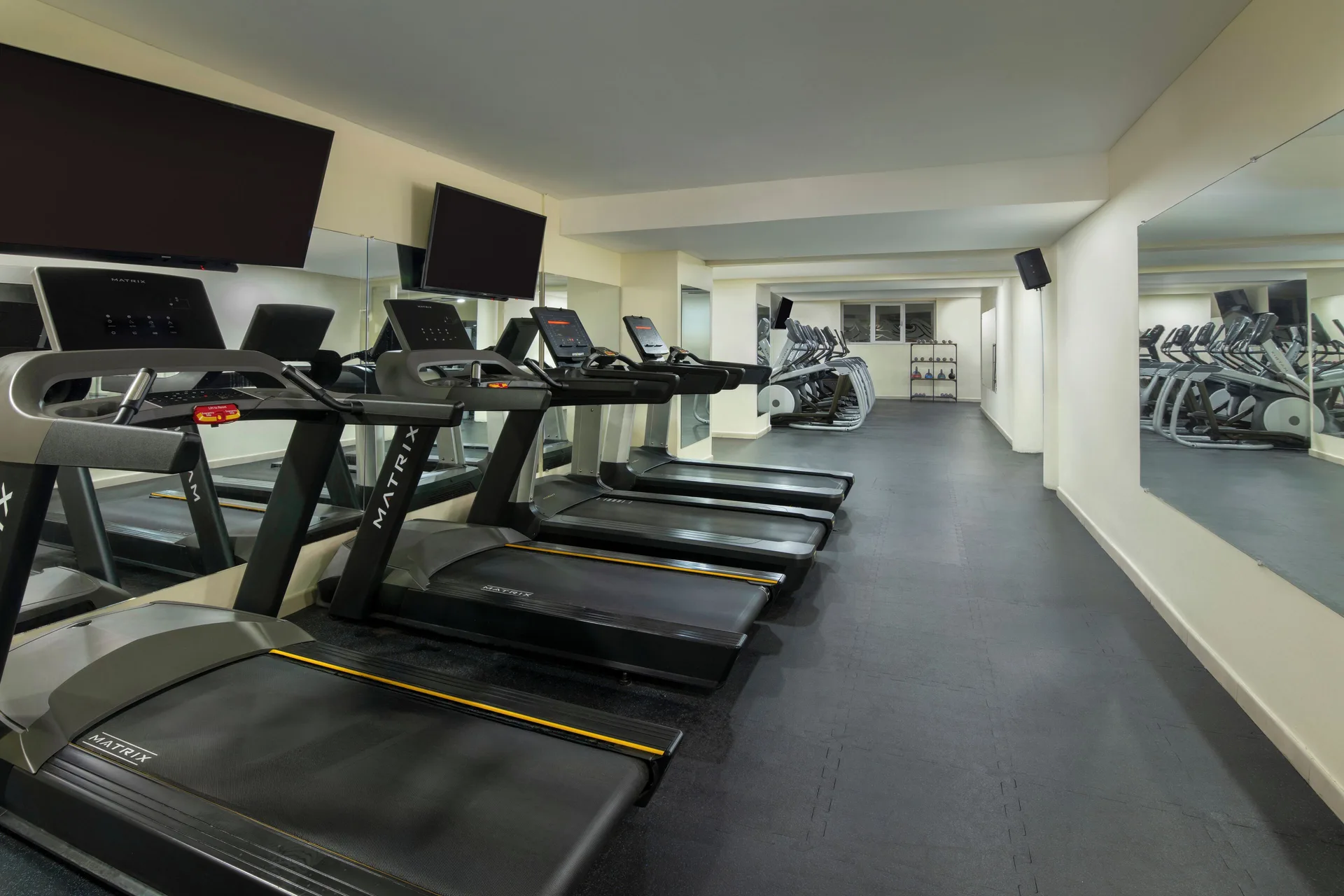 Fitness room with treadmills and mirrored walls at Impressive Premium Punta Cana.