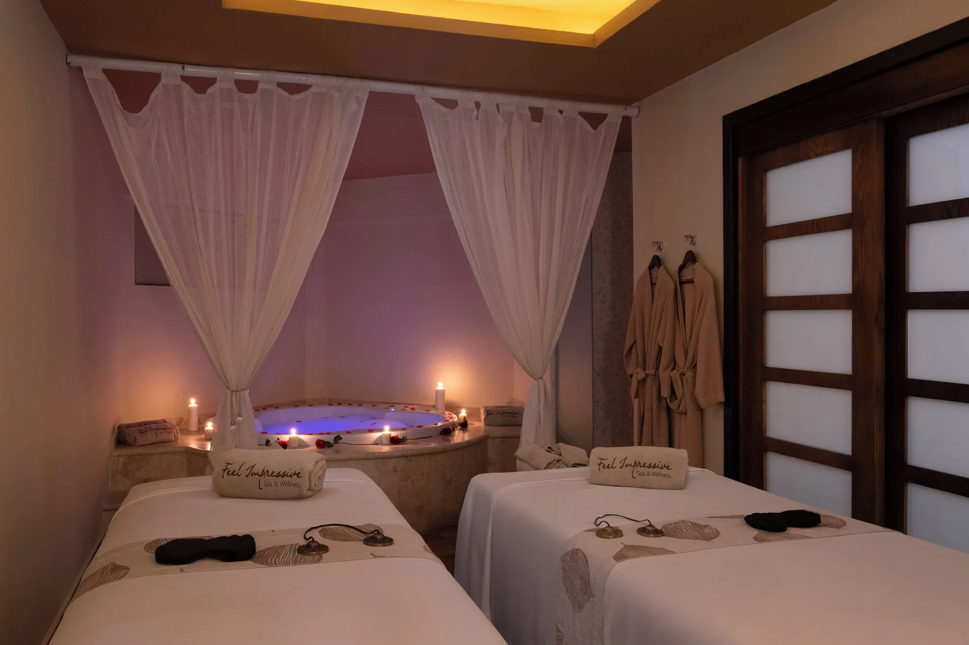 Twin spa treatment beds and a candlelit tub at Impressive Premium Punta Cana.