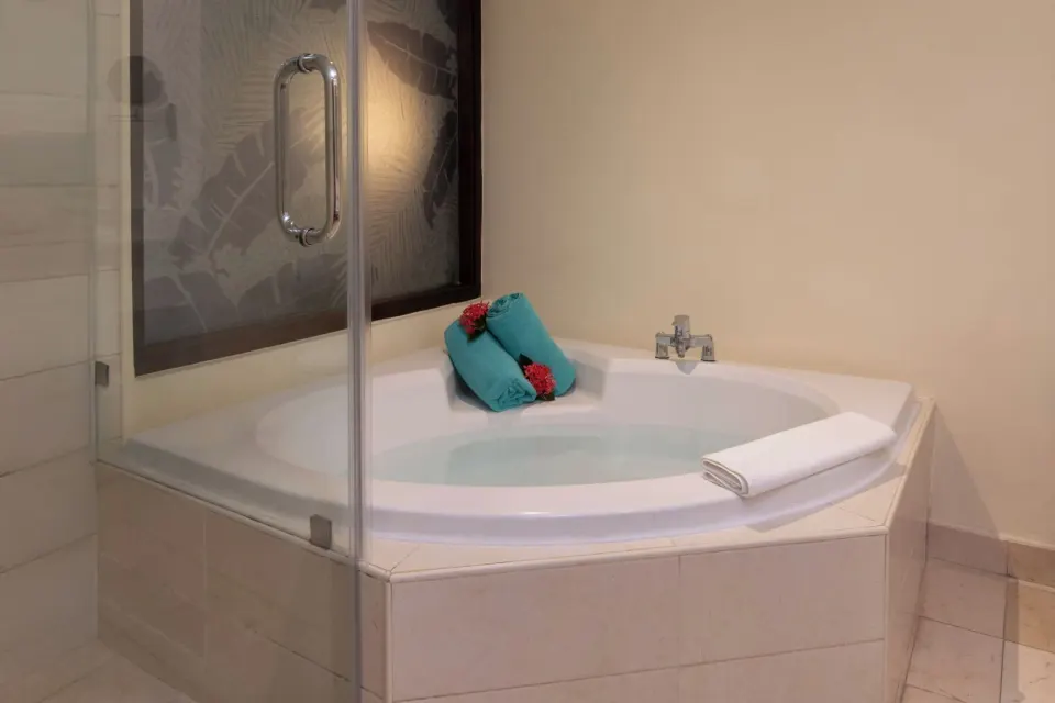 Corner Jacuzzi tub with towels in a junior suite at Impressive Premium Punta Cana.