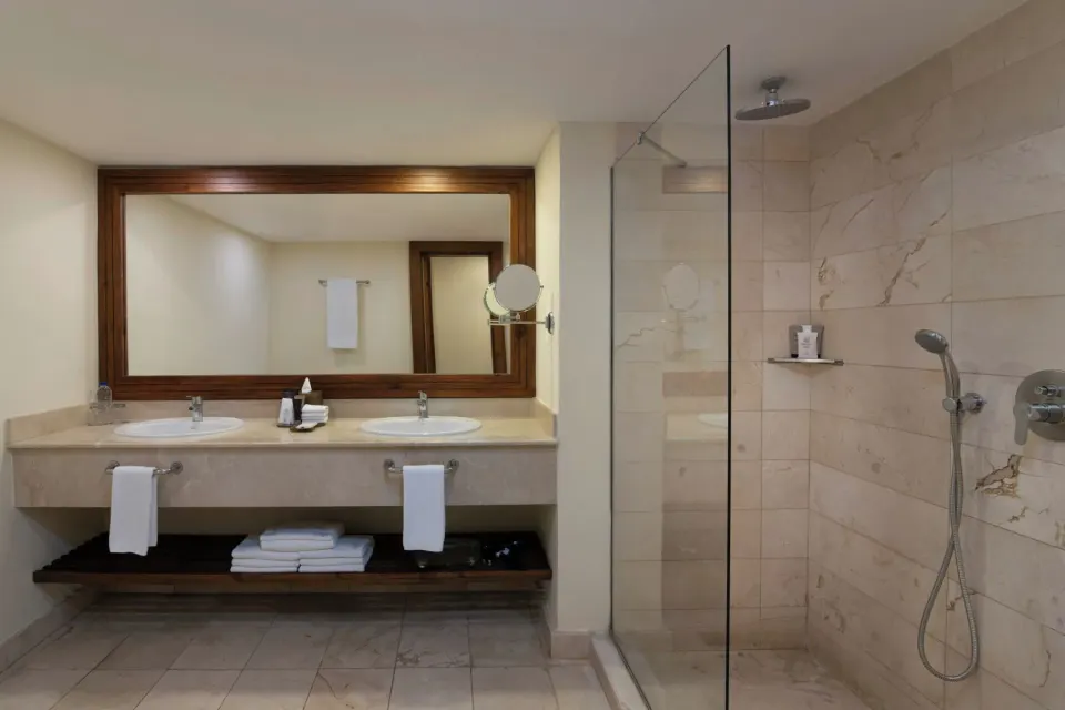 Double vanity and glass shower in a junior suite bathroom at Impressive Premium Punta Cana.