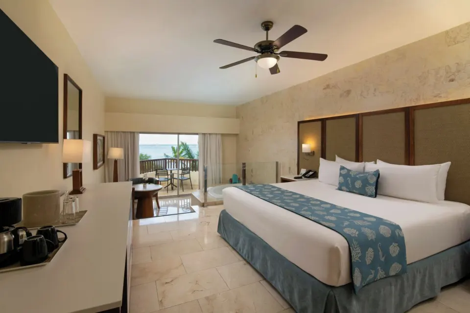 Oceanfront junior suite king bed with balcony and Jacuzzi at Impressive Premium Punta Cana.