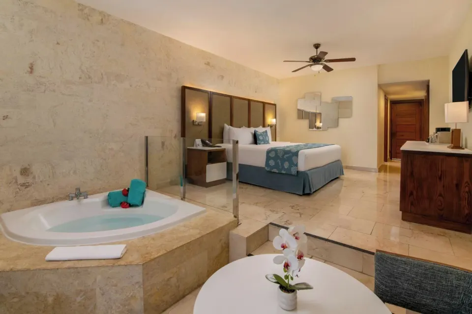 Junior suite with king bed, in-room Jacuzzi and sitting area at Impressive Premium Punta Cana.