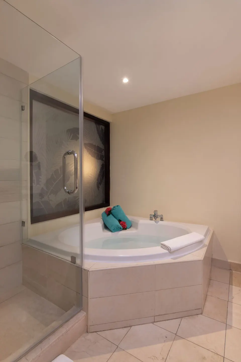 Junior Suite bathroom with corner Jacuzzi tub and glass shower at Impressive Premium Punta Cana.
