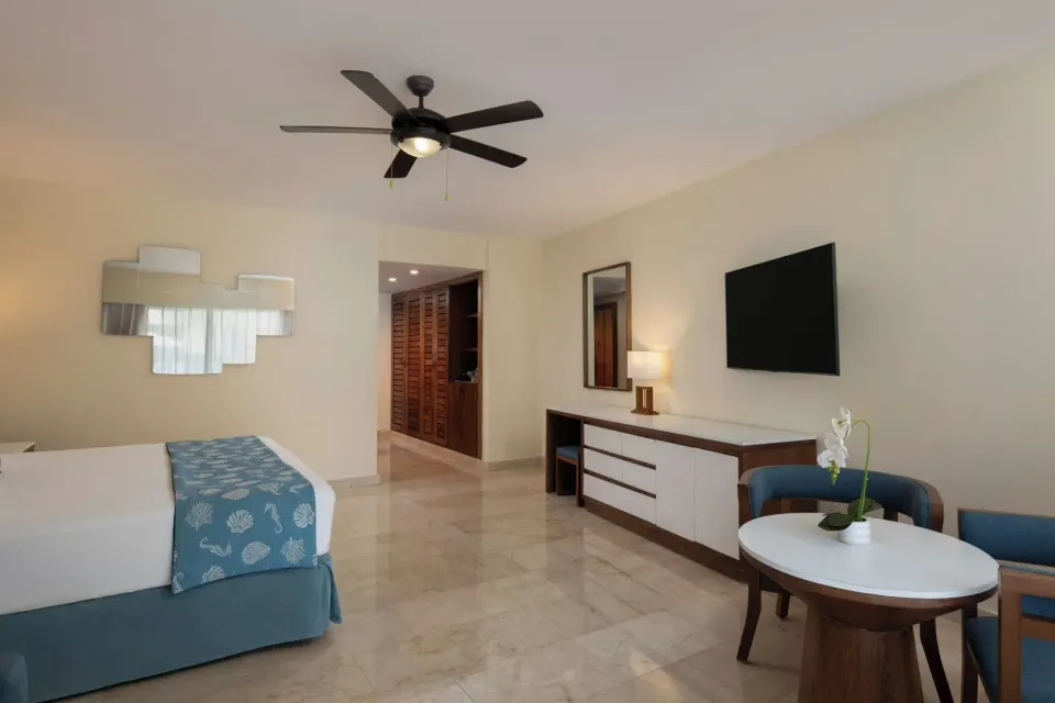 Junior Suite Premium Pool View room with king bed and seating at Impressive Premium Punta Cana.