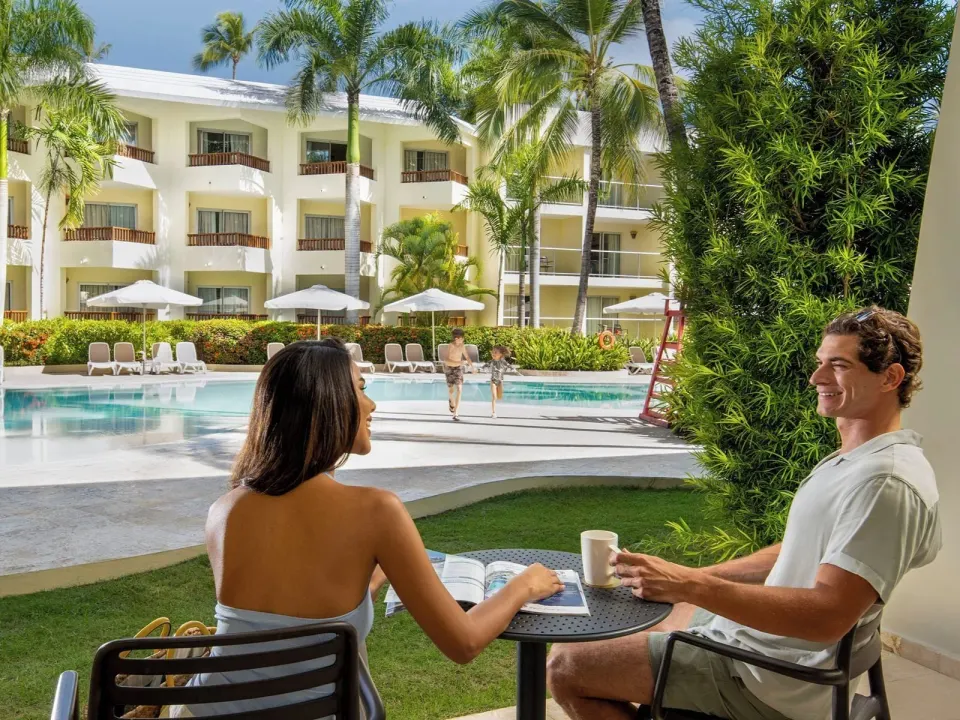 Guests seated on a Junior Suite Premium Pool View patio at Impressive Premium Punta Cana.