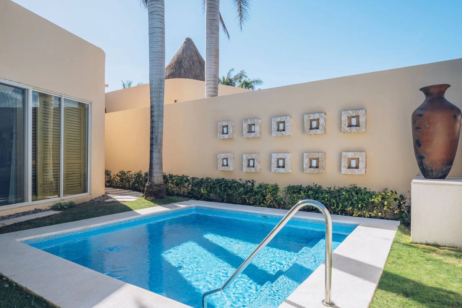 Romantic Villa private pool with wall decor and palms at JOIA Paraíso by Iberostar.