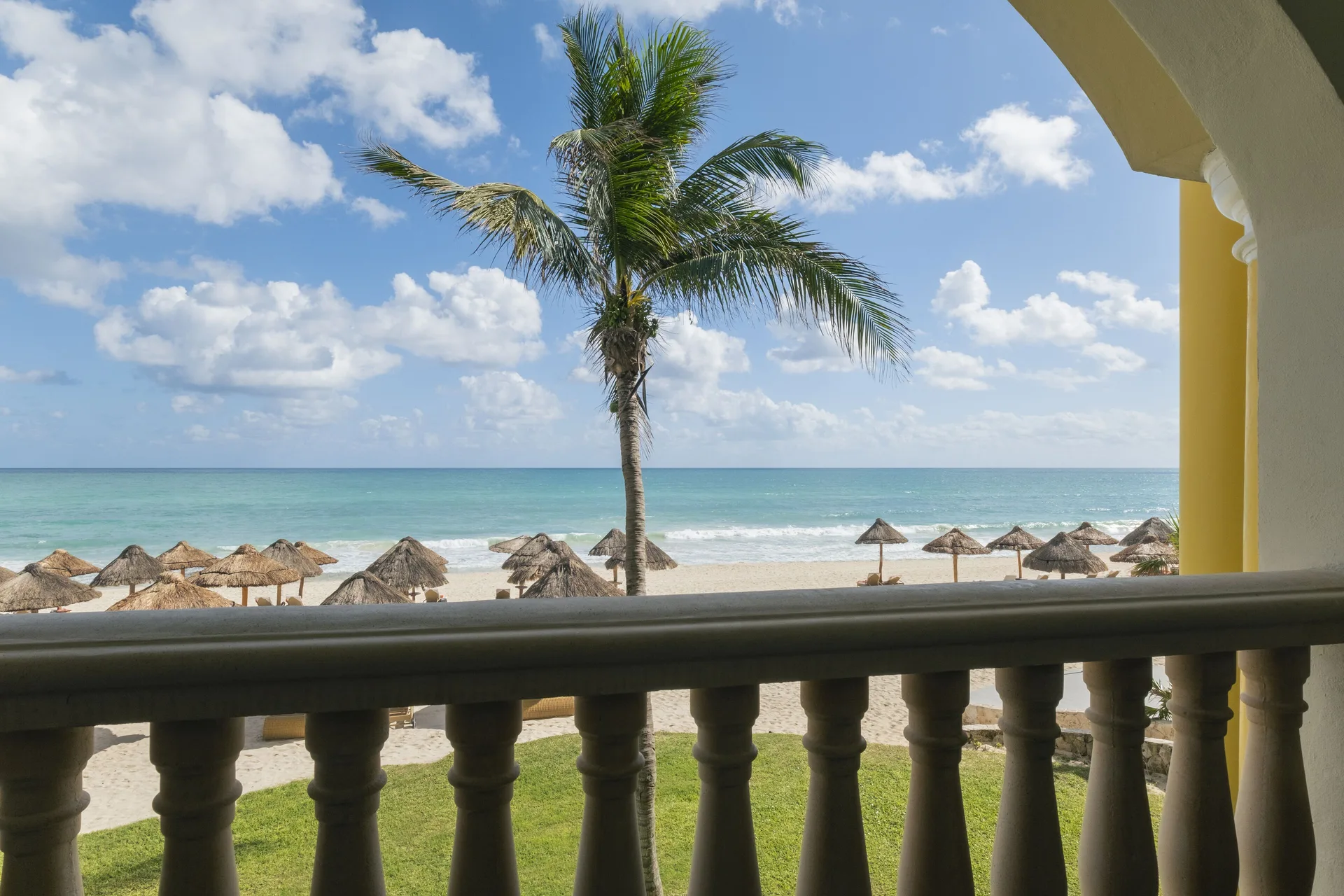 Oceanfront Suite balcony view of beach, palm and turquoise sea at JOIA Paraíso by Iberostar.