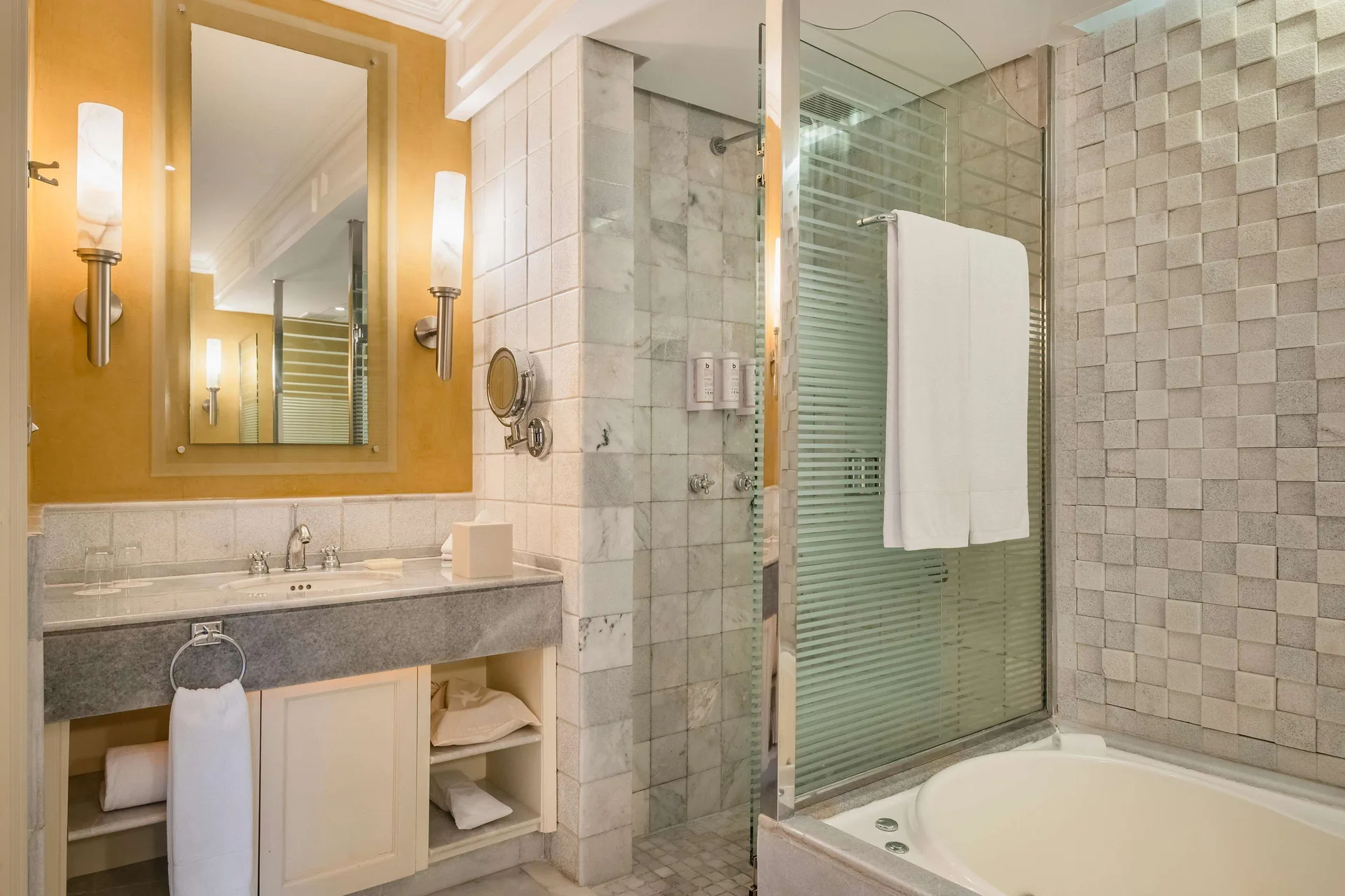 Oceanfront Suite bathroom vanity and tub with glass shower at JOIA Paraíso by Iberostar.
