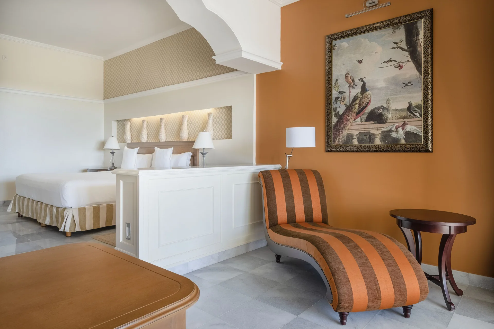 Oceanfront Suite sitting area with chaise lounge and king bed at JOIA Paraíso by Iberostar.