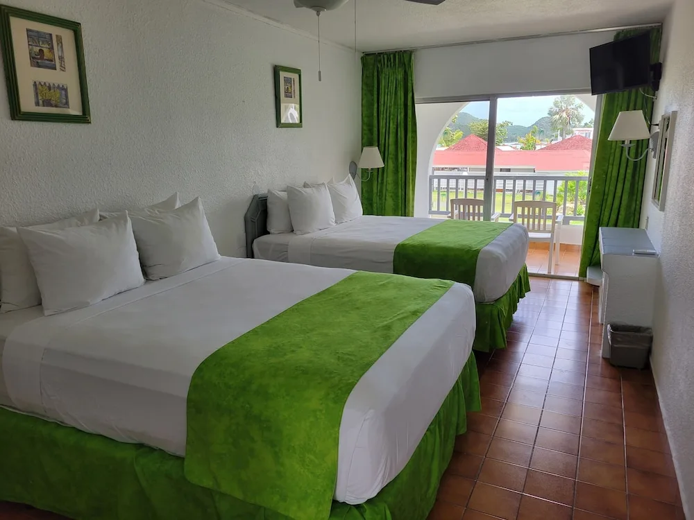 Two-bed guest room with balcony and hillside view at Jolly Beach Antigua.