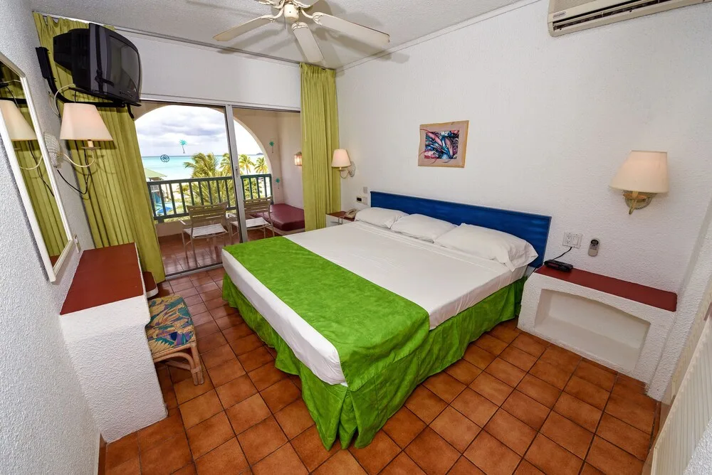 King bed guest room with balcony and sea view at Jolly Beach Antigua.