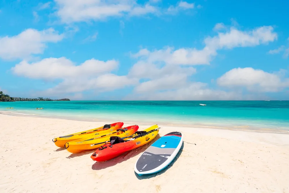 Kayaks and a paddleboard on the beach at Jolly Beach Antigua.