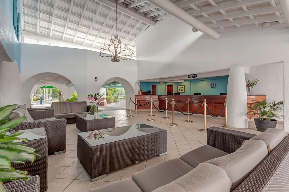 Open-air lobby lounge and reception desk at Jolly Beach Antigua.