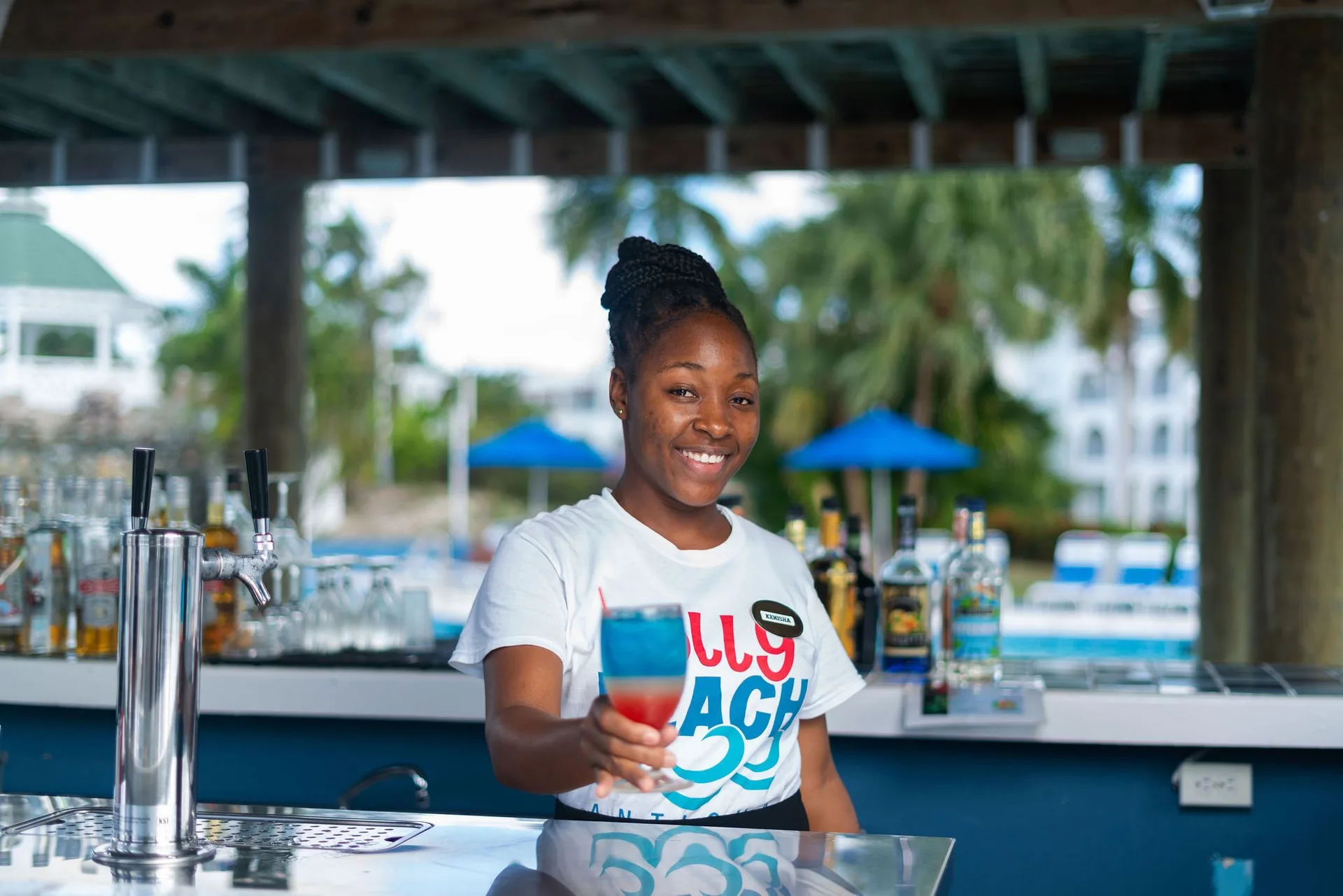 Bartender serving a layered cocktail at the pool bar at Jolly Beach Antigua.