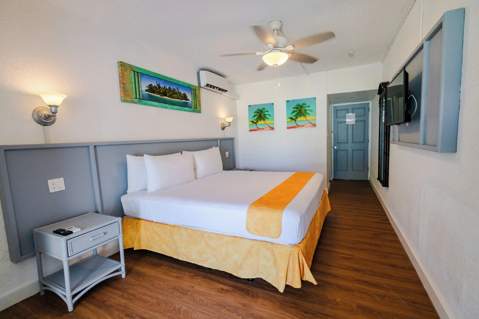 Superior Room king bed facing the entry door and TV at Jolly Beach Antigua.