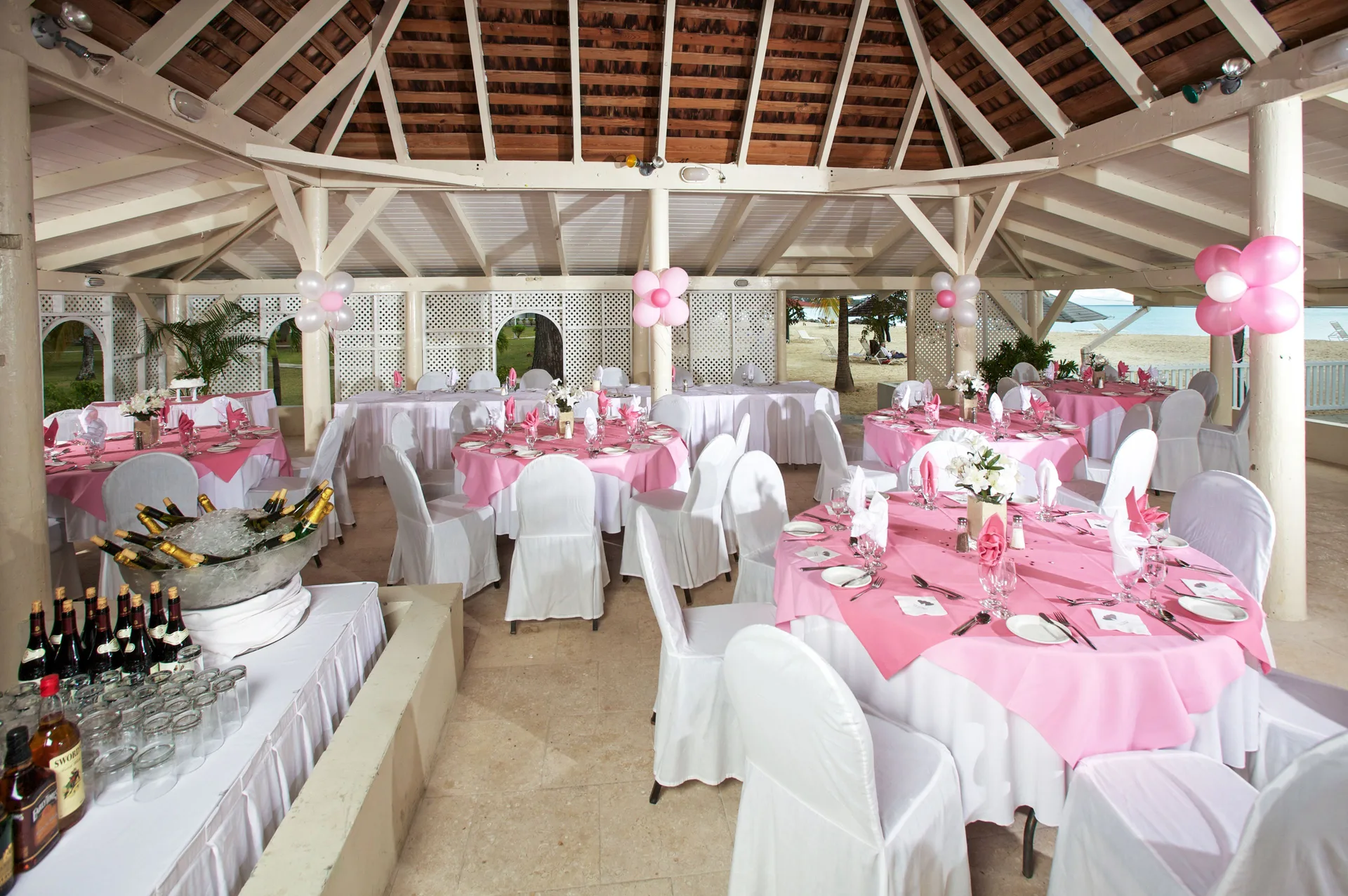 Decorated banquet pavilion with pink table settings at Jolly Beach Antigua.