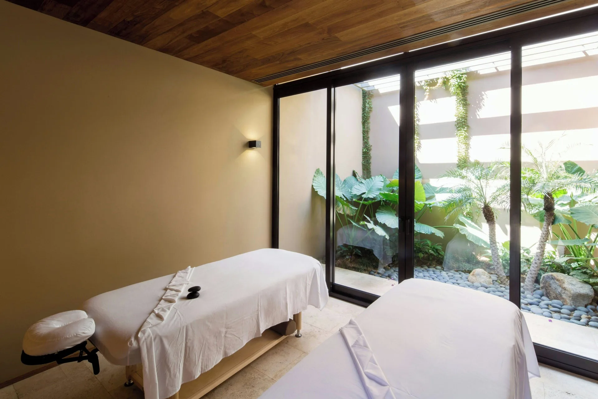 Spa treatment room with garden-facing glass doors at JW Marriott Los Cabos Beach Resort & Spa.
