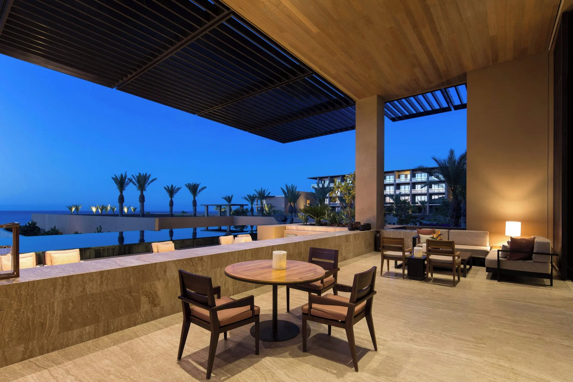 Covered terrace lounge with ocean and palm views at JW Marriott Los Cabos Beach Resort & Spa.
