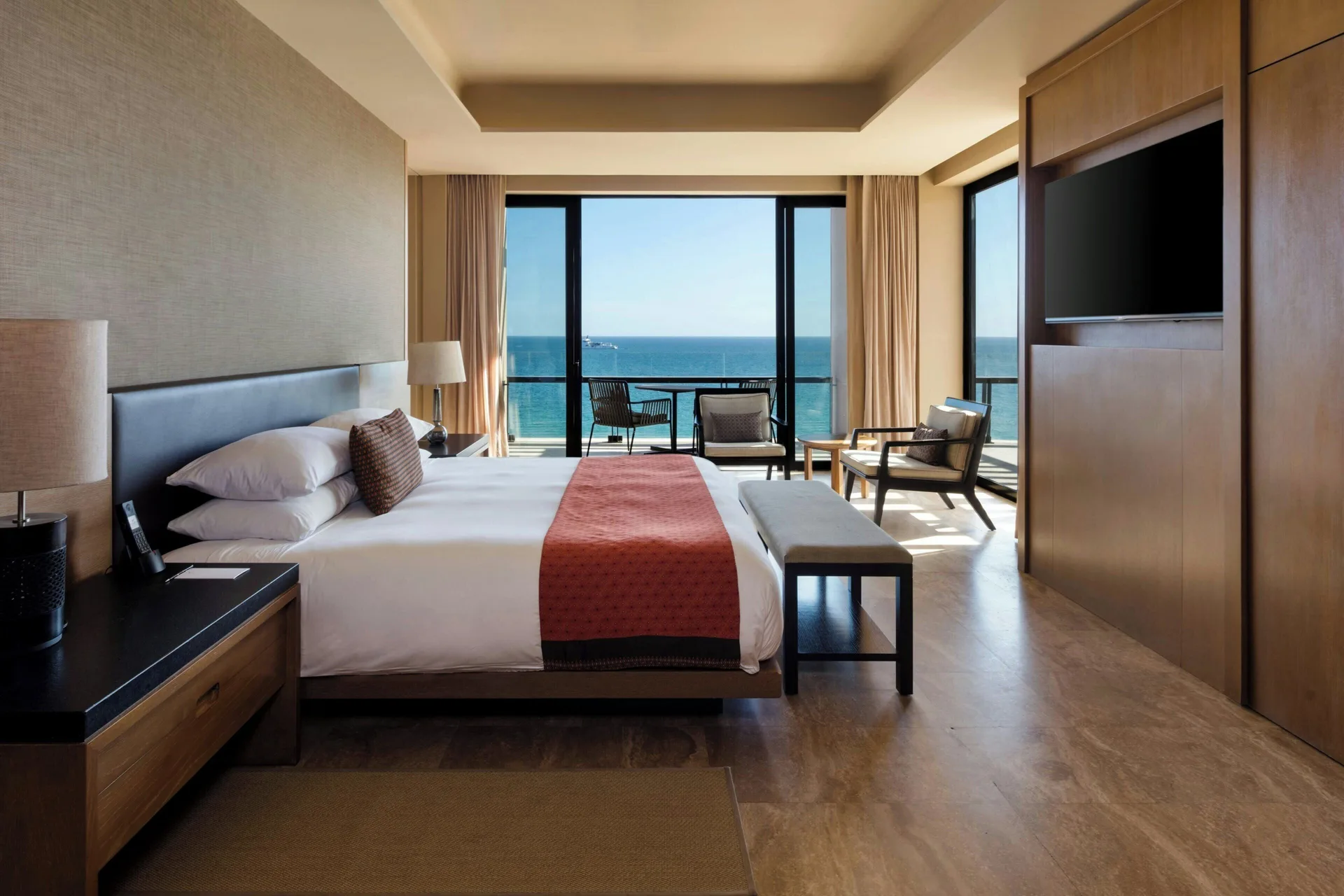Oceanfront suite bedroom with king bed and balcony view at JW Marriott Los Cabos Beach Resort & Spa.