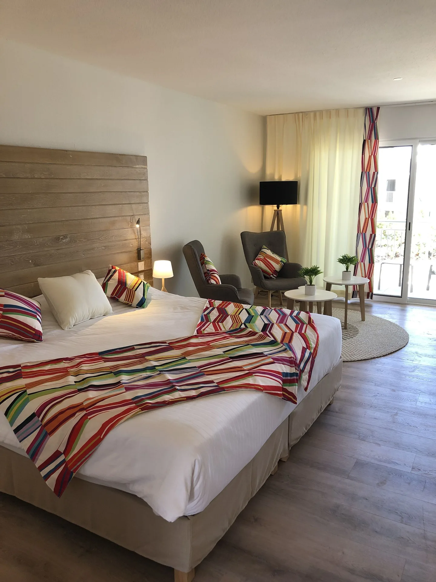Classic Suite bed and seating area with balcony doors at La Playa Orient Bay.
