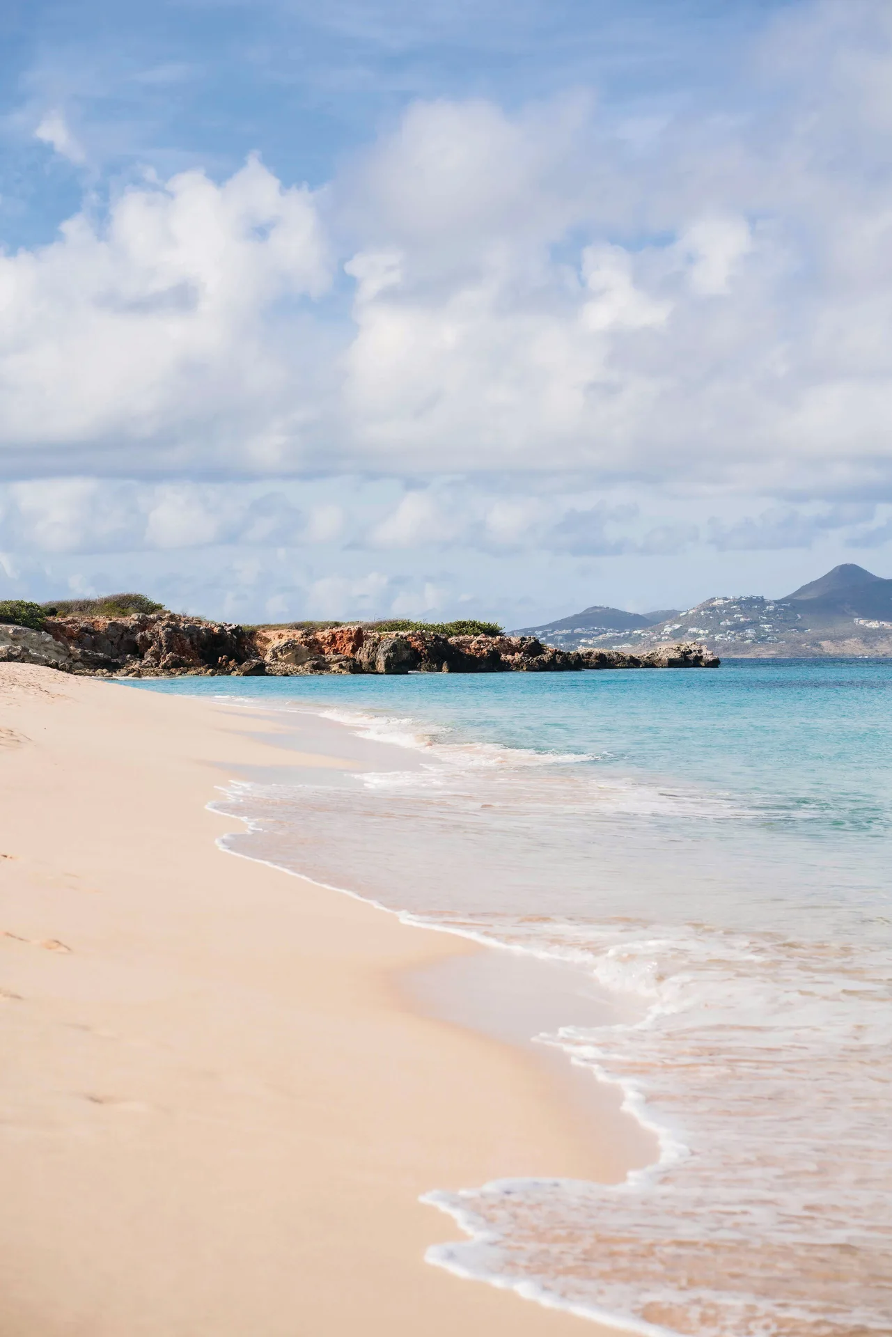 Sandy beach with turquoise water and distant hills at La Samanna, St Martin.